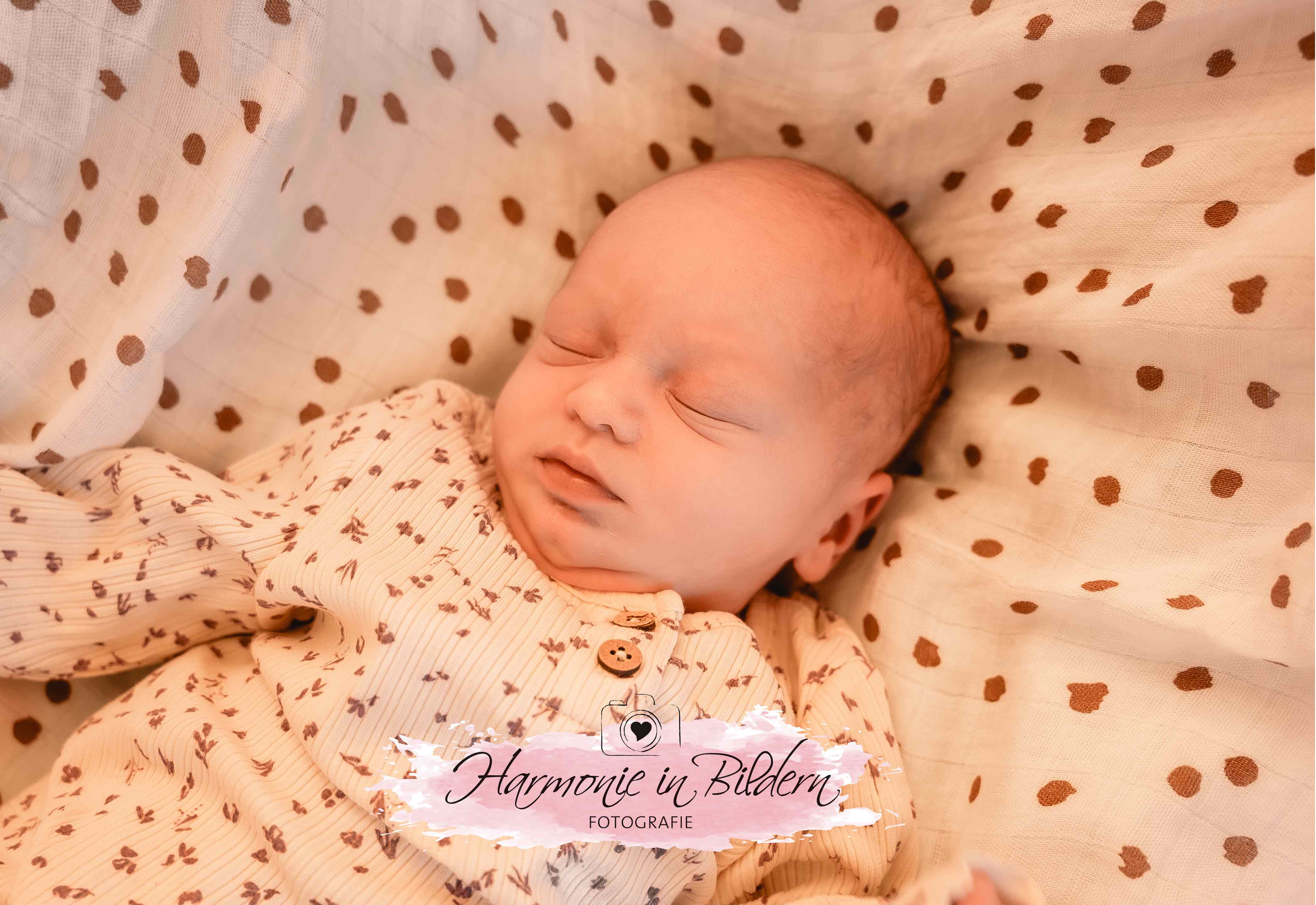 Neugeborenes  Mädchen, wenig haare ,auf gepunkteter Decke