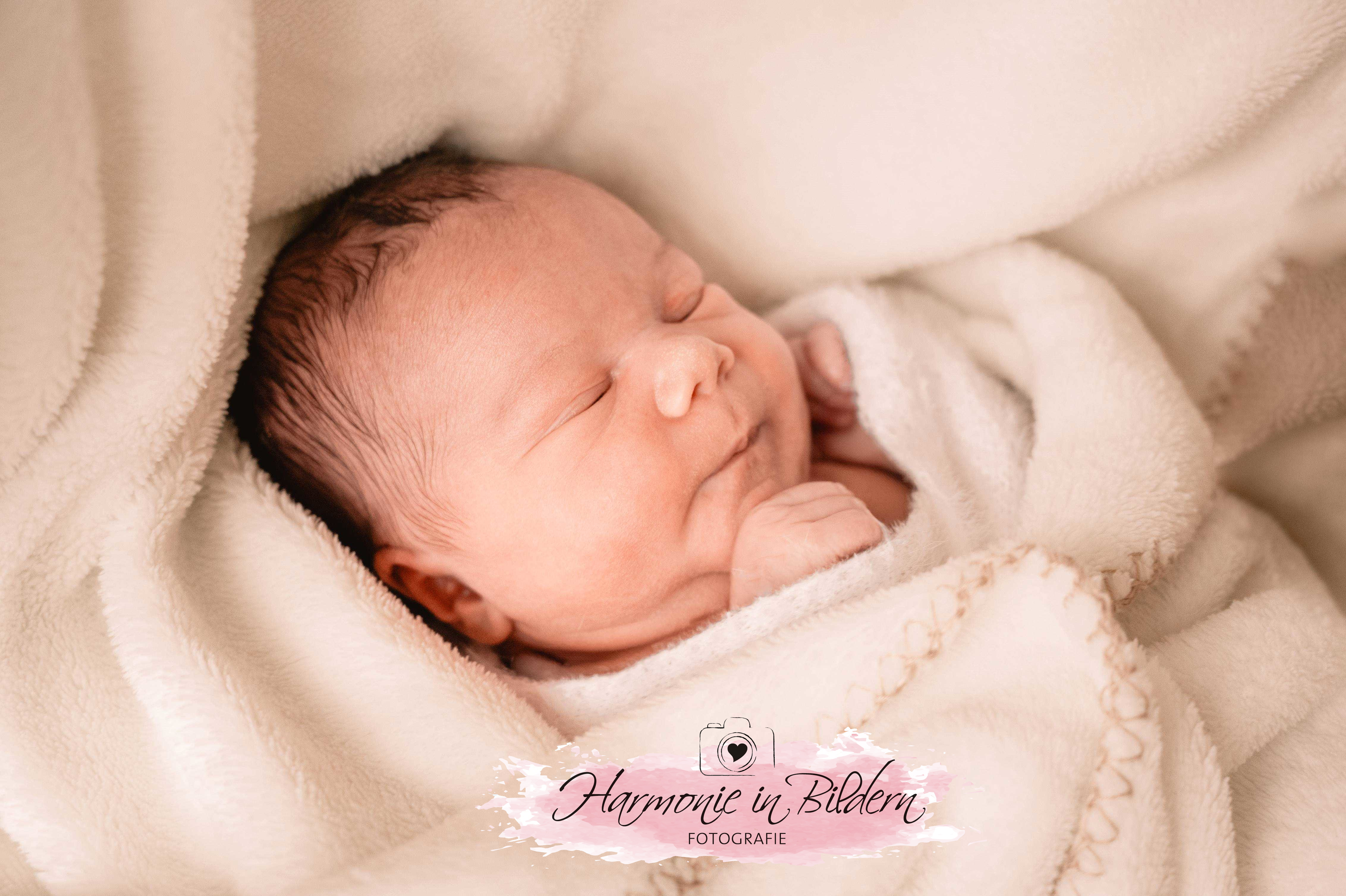 Neugeborenes Baby , Mädchen,dunkle Haare auf weisser Decke