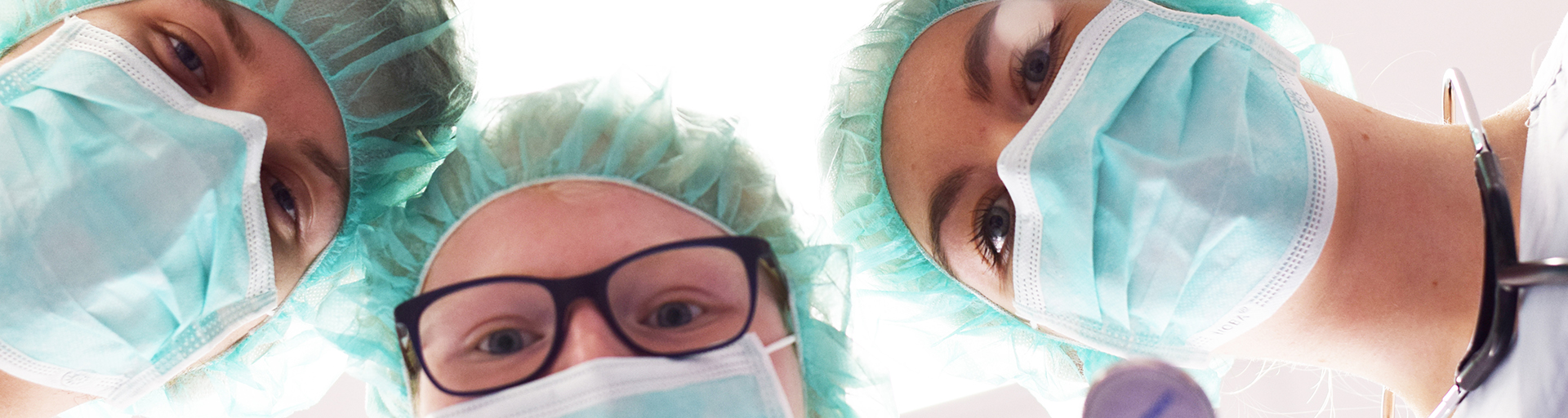 Drei Ärzte bei eine Operation.