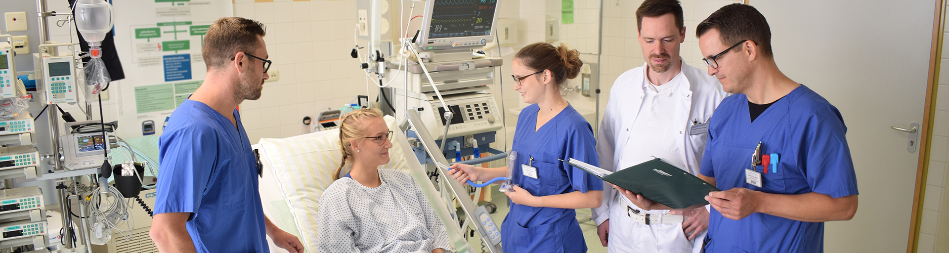 Ein Arzt und Pflegepersonal sind bei einer Patientin zur Visite.