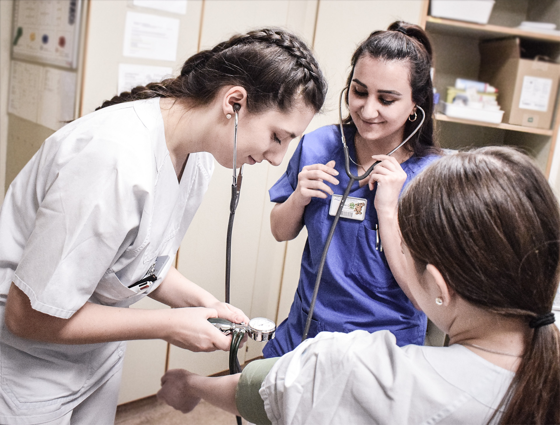 Junge Frauen messen Blutdruck und Puls.