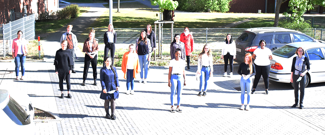 Junge Menschen stehen auf einem Parkplatz.