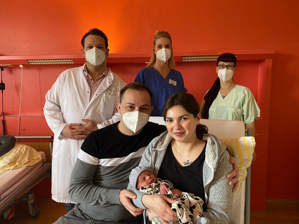 Die Eltern mit ihrem Baby im Arm.