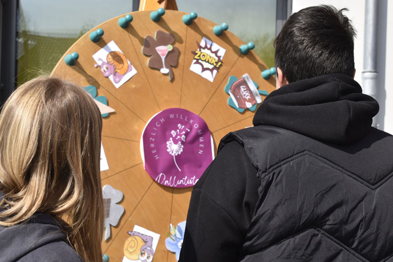 Zwei Personen drehen an einem Glücksrad.