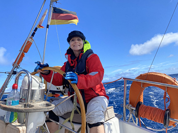 Eine Frau am Steuer einer Segelyacht.