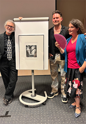 Drei Personen vor einer Pinnwand.