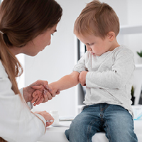 Eine Ärztin untersucht einen kleinen Jungen. 